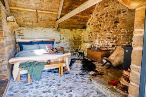 Bedroom in the barn with stone walls and timber beams