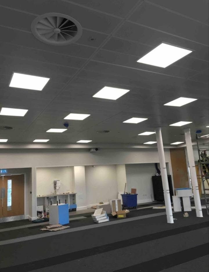 Open-plan office with LED ceiling panels being installed