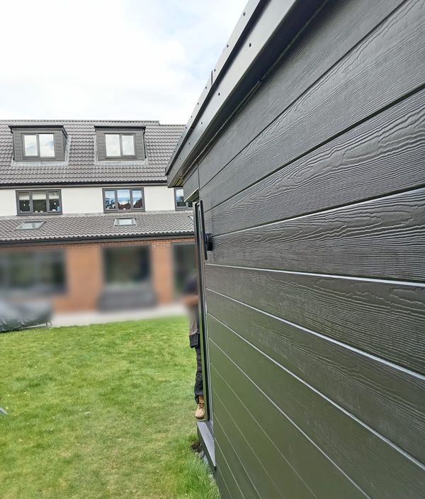 Clad garden room at the end of a lawn